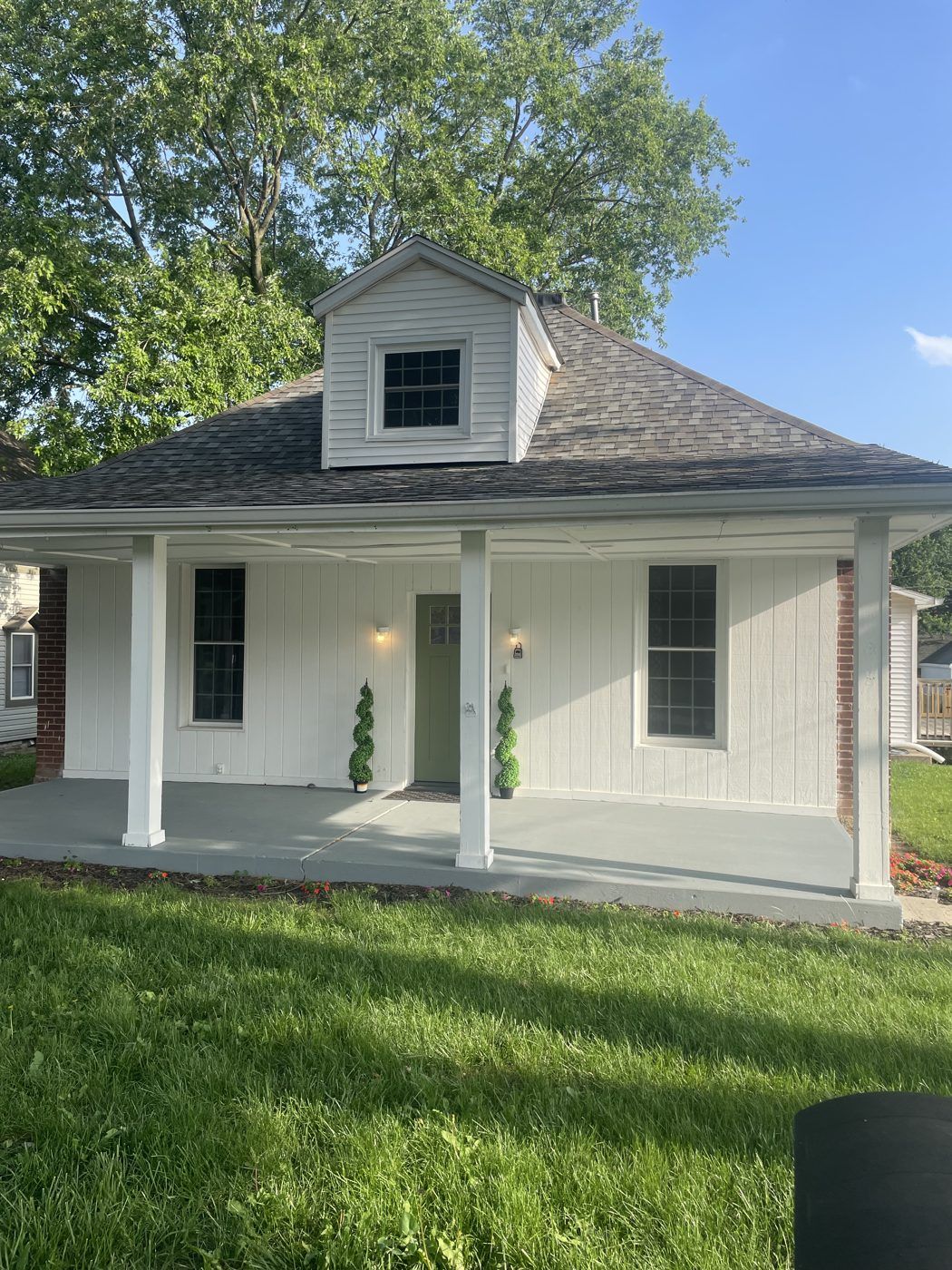 A white cottage-style home with a covered front porch