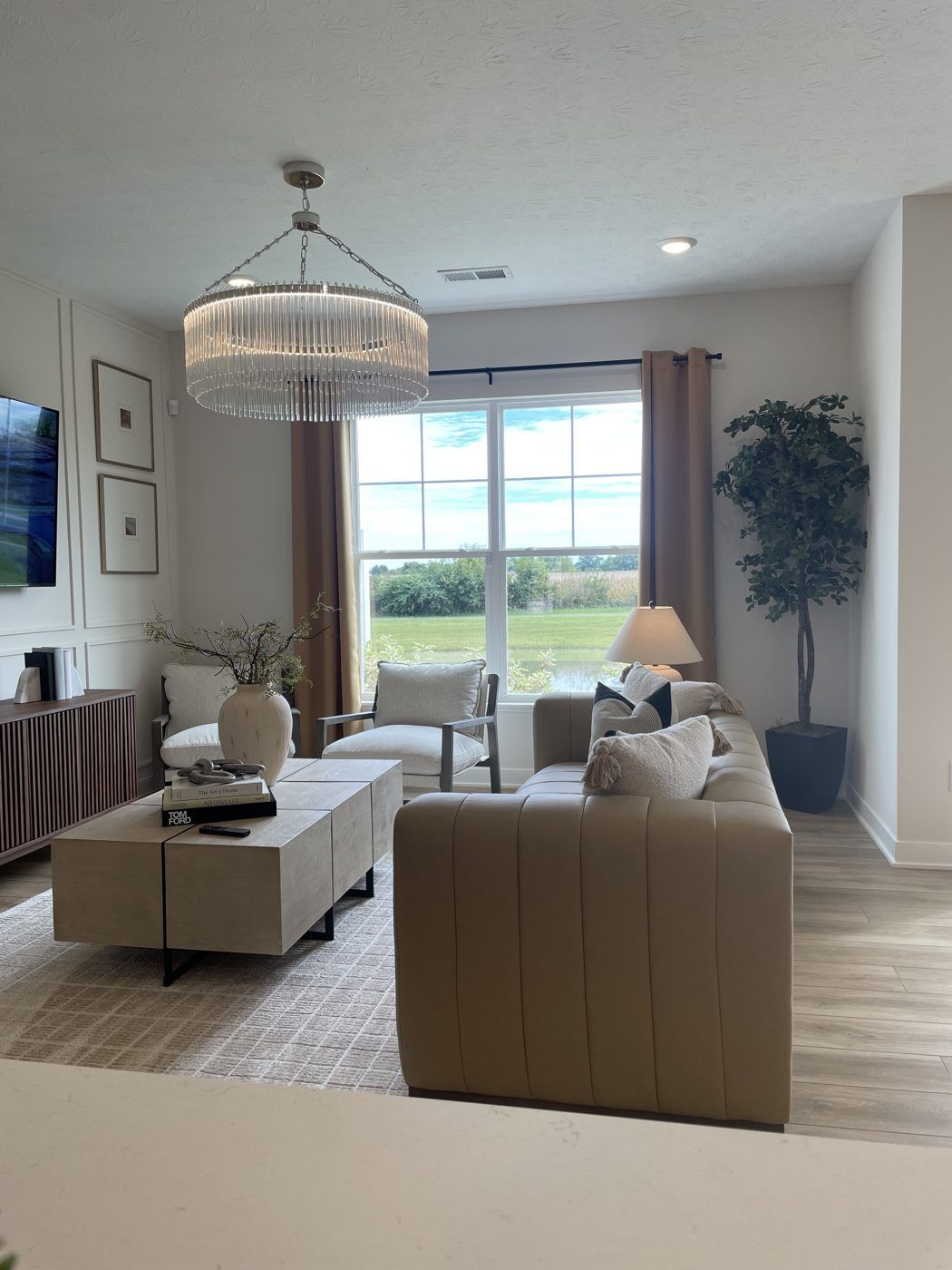 A bright, staged living room with a chandelier